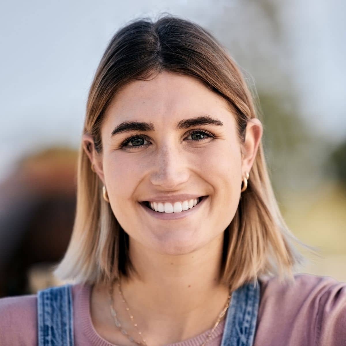 Portrait d’une cliente satisfaite ayant laissé un avis positif après une intervention de plomberie ou une rénovation sanitaire.